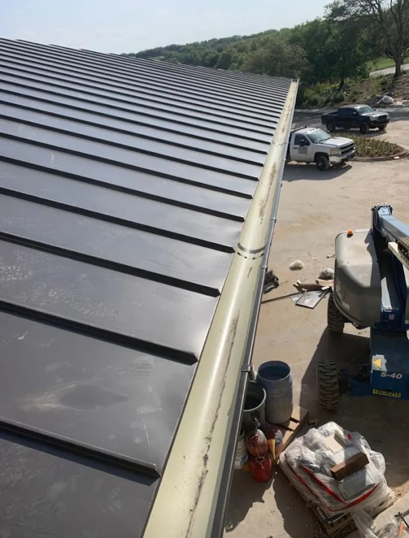 Standing seam panel and gutter detail on a metal roofing jobsite in Greenwood